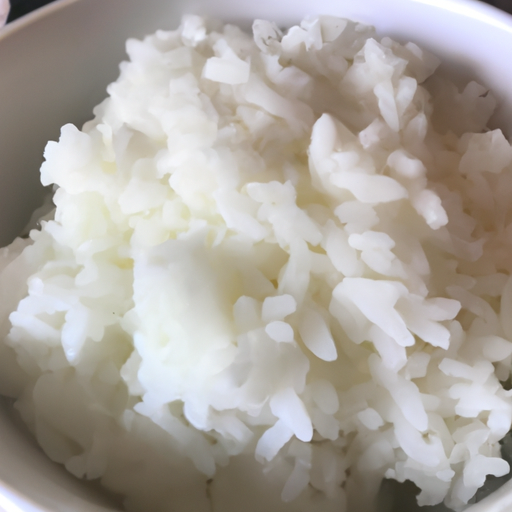 A bowl of fluffy white rice, perfectly cooked and ready to be paired with dumplings.